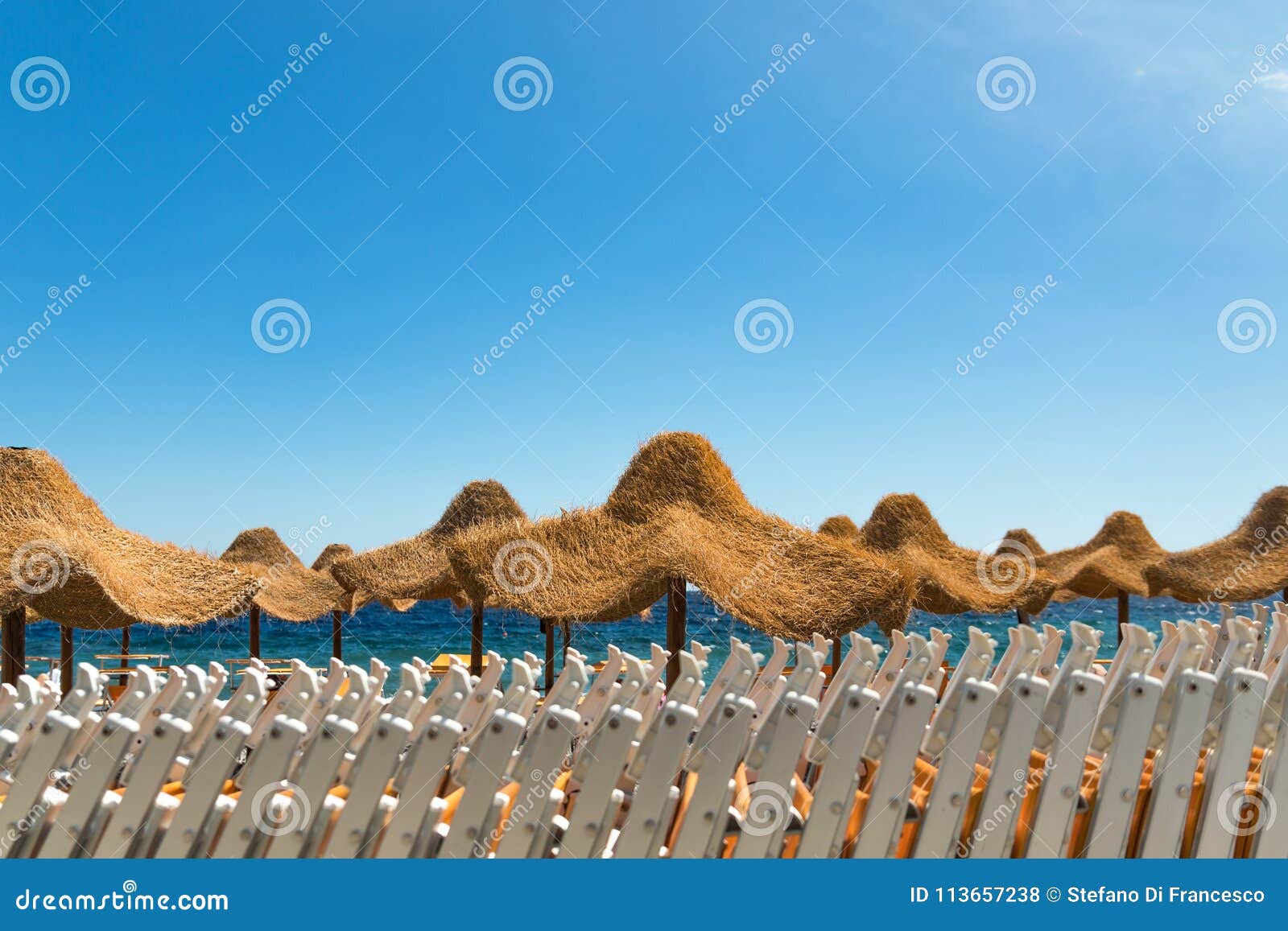 Beach Chairs and Umbrellas Entering at the Beach Club Stock Photo
