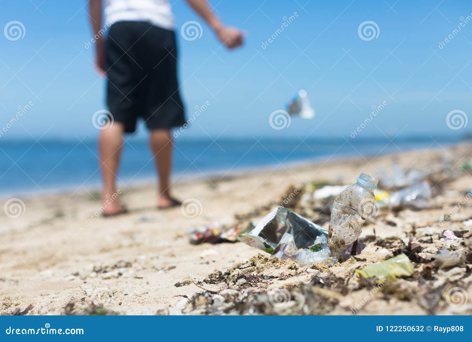 A Man Casually Throws Garbage on the Ground, Adding To the Large Amount of Litter at the Beach