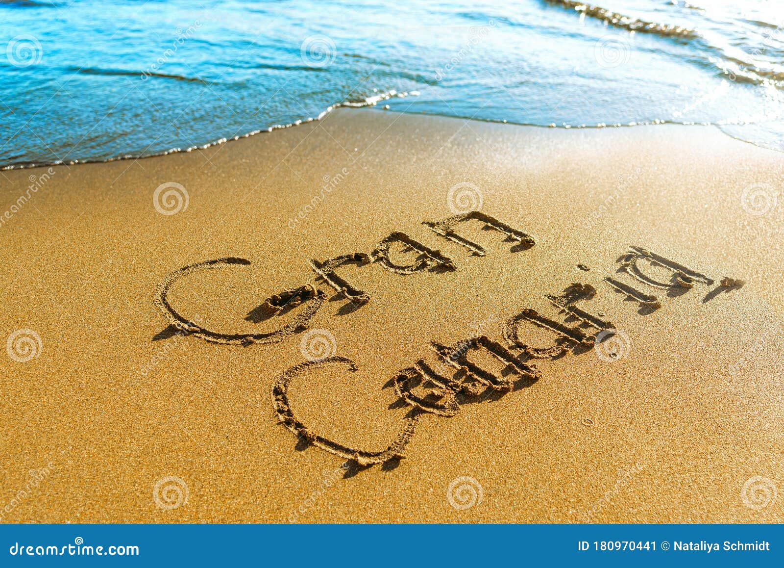 beach. gran canaria is written on the sea sand