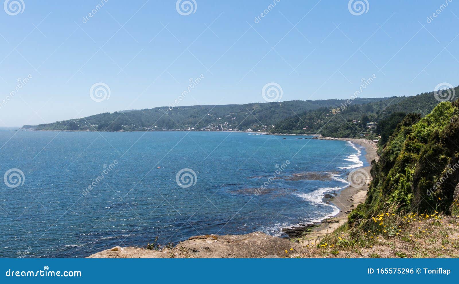 beach lovers facing the pacific ocean from the fort of niebla village. estuary and mouth of the valdivia river. valdivia, los rios