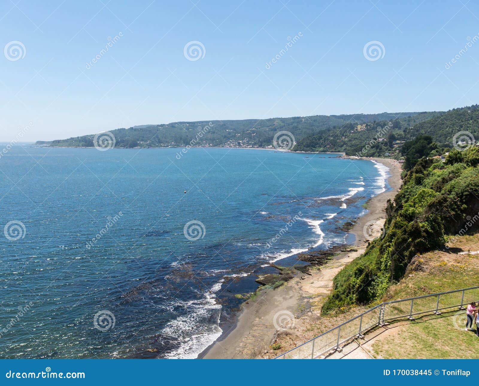 beach lovers facing the pacific ocean from the fort of niebla village. estuary and mouth of the valdivia river. valdivia, los rios