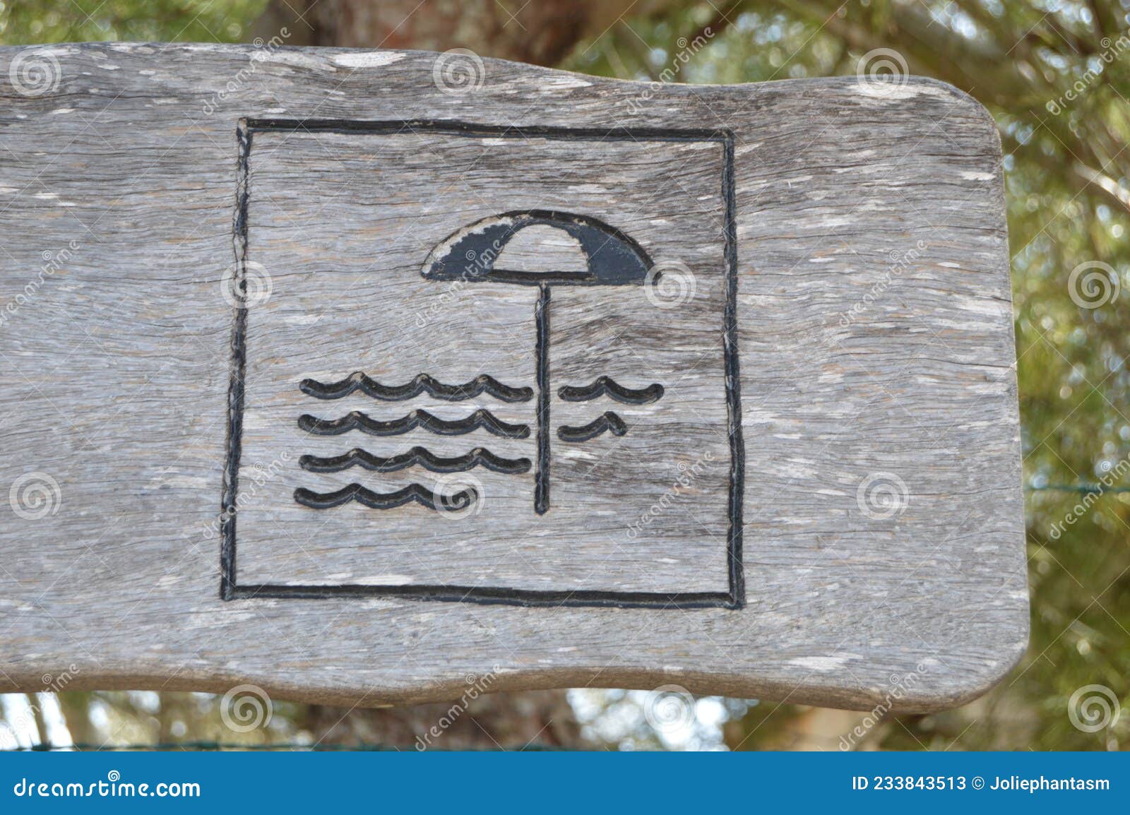 beach sign on wood. parasol and waves drawn on wood.