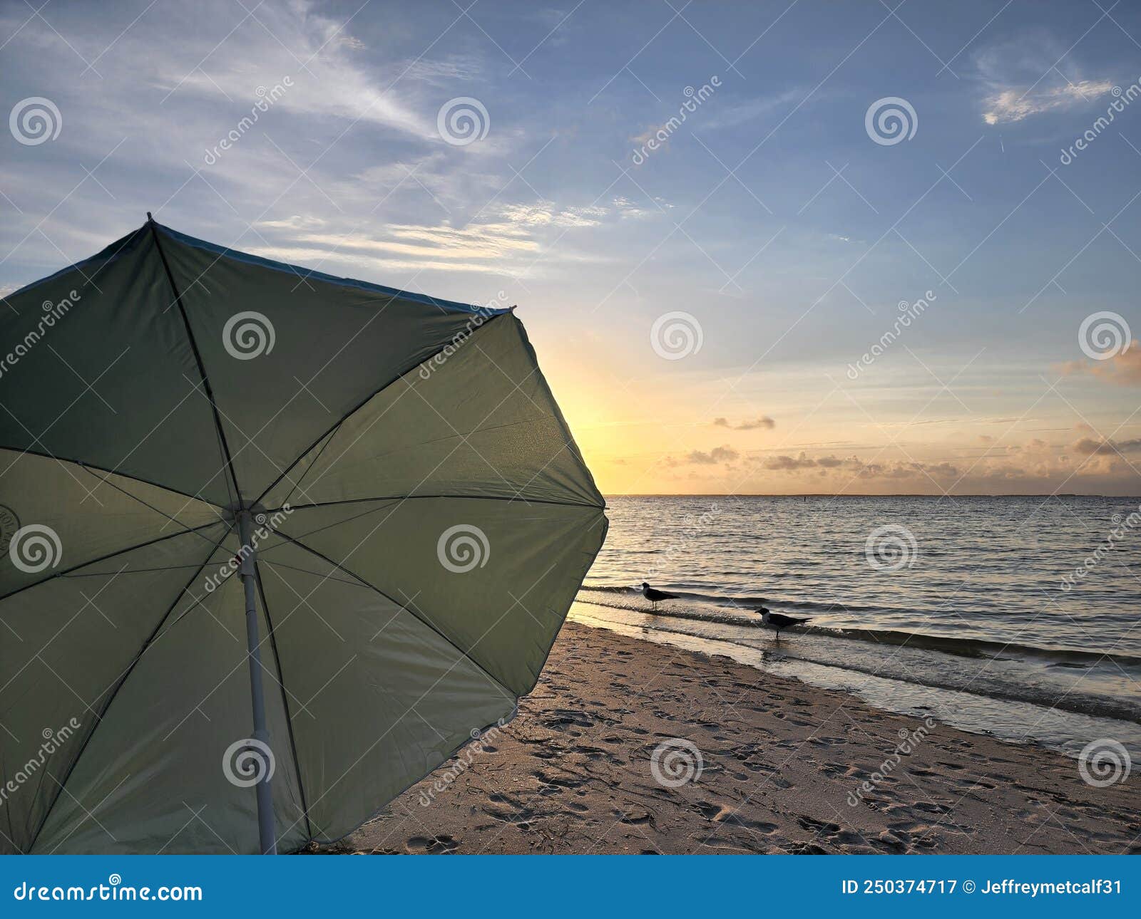 Beach sunset with umbrella stock image. Image of sunset 250374717