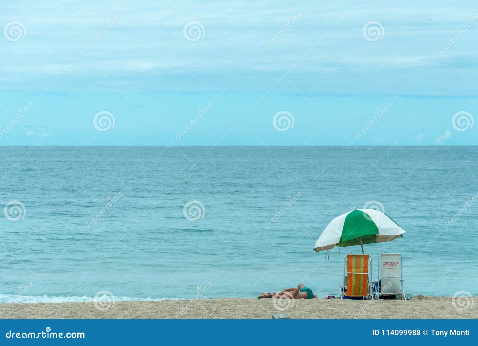 Beach Tent Umbrella A Person And Two Chairs On The