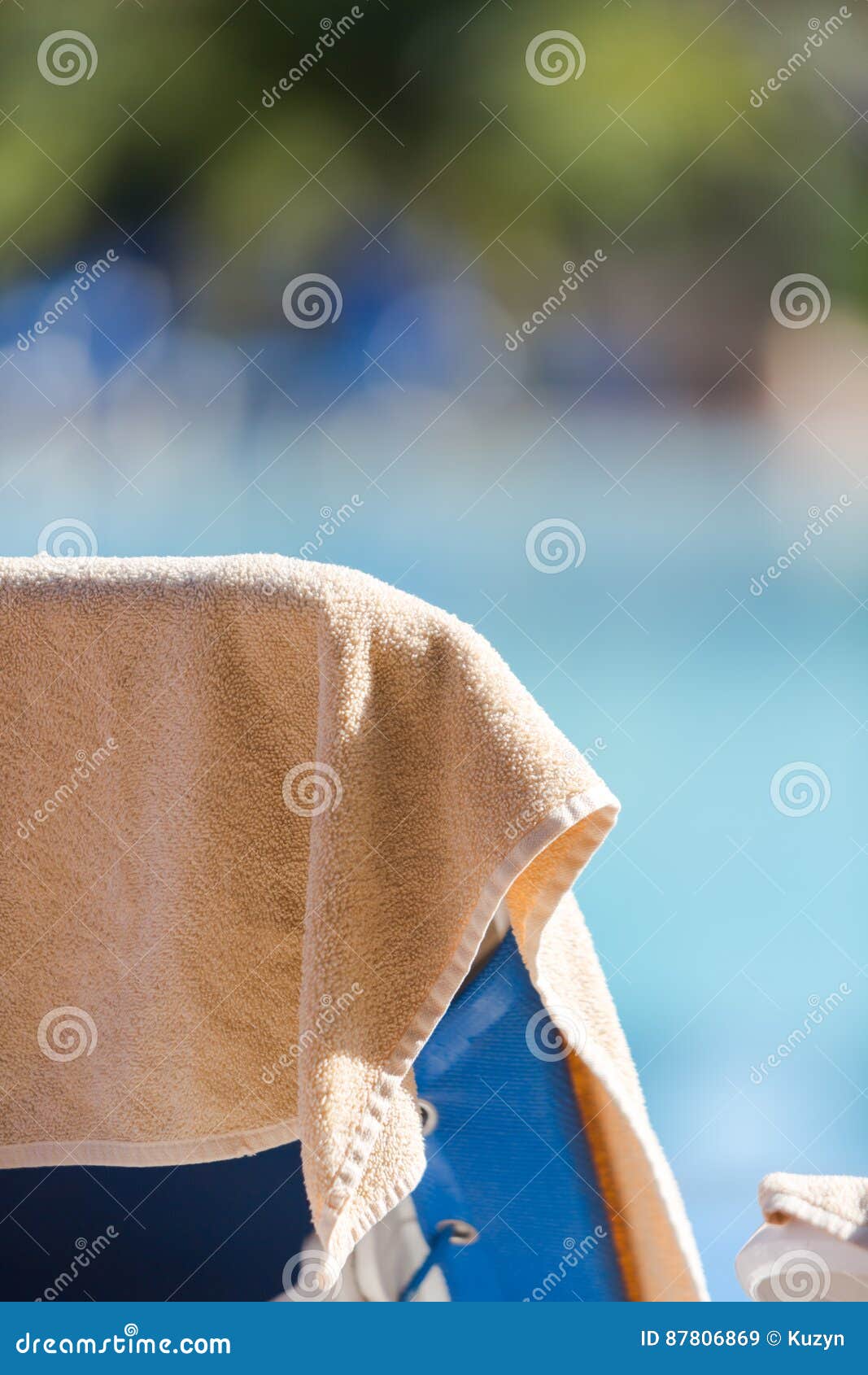 Beach Towel In Cream Color Hung On The Empty Deck Chair By