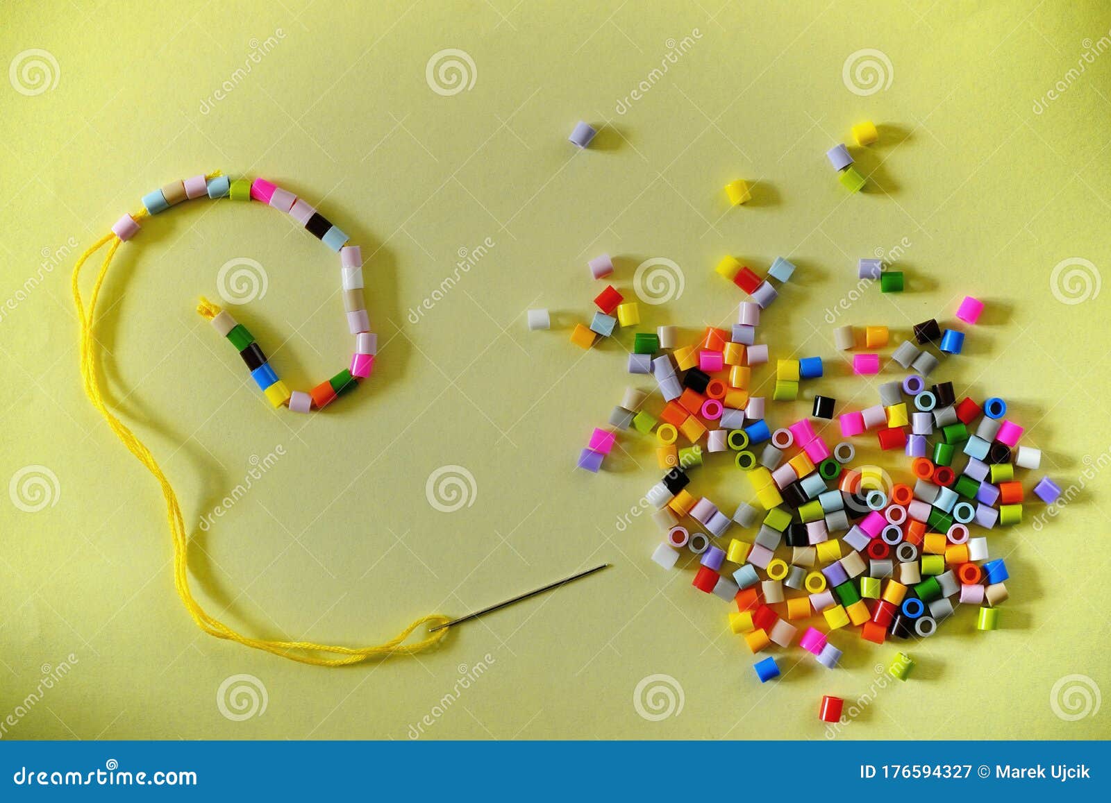 Beads Strung on Yellow Cotton with a Needle and a Pile of Other Colored ...