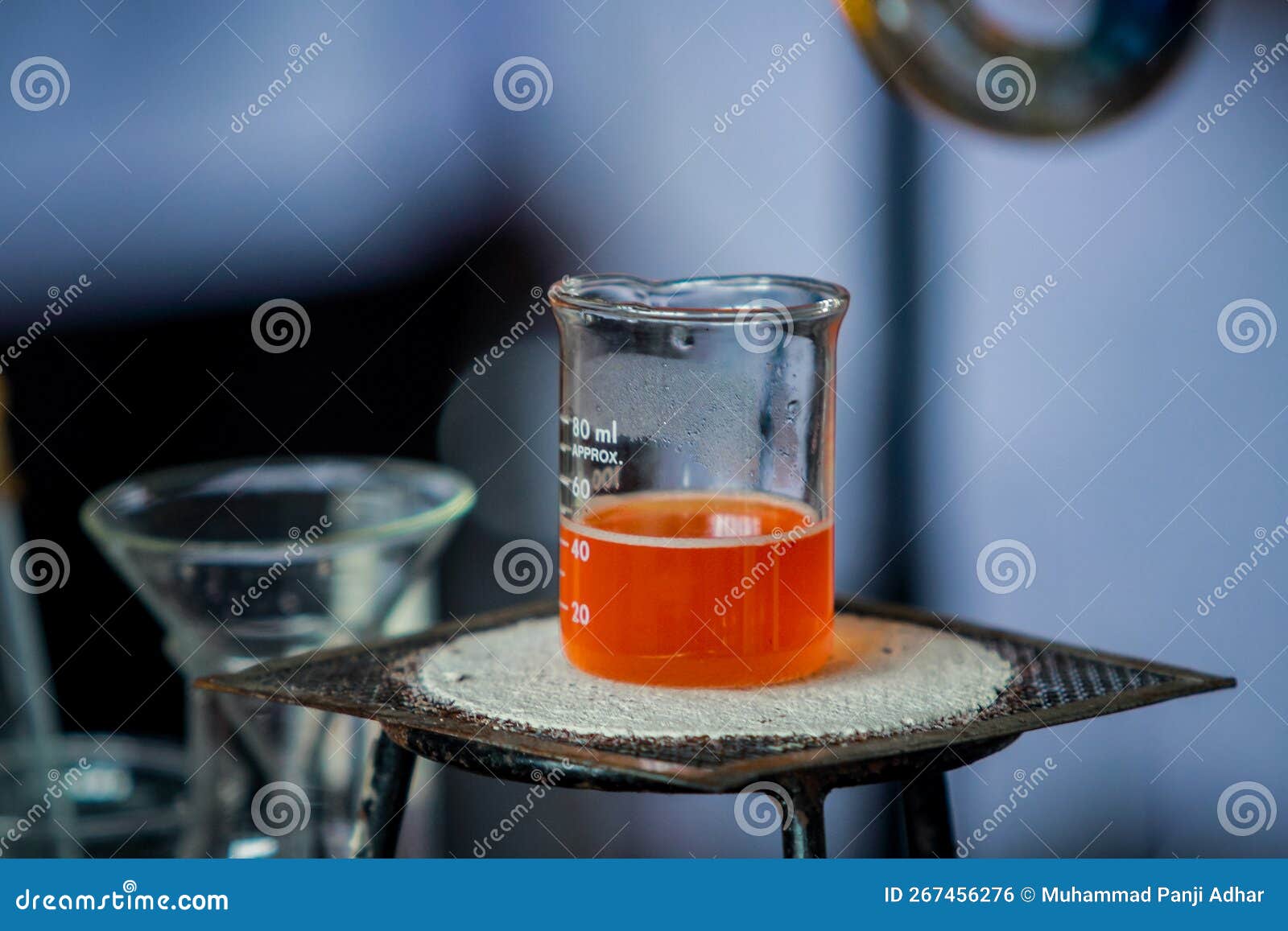 Orange Colored Chemical Solution in a Chemical Measuring Cup Stock