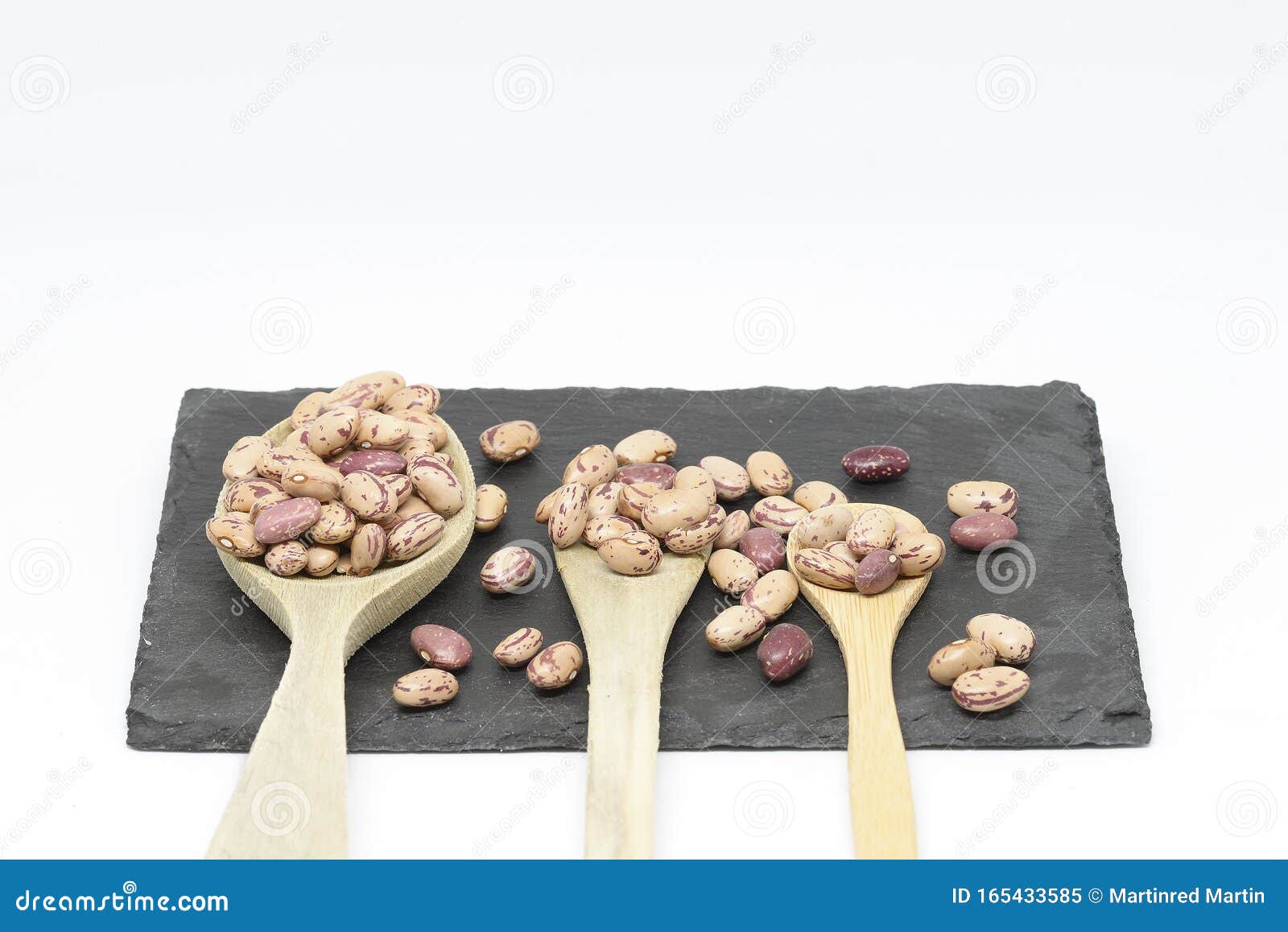 bean pint or bean with wooden spoon on slate plate and white background
