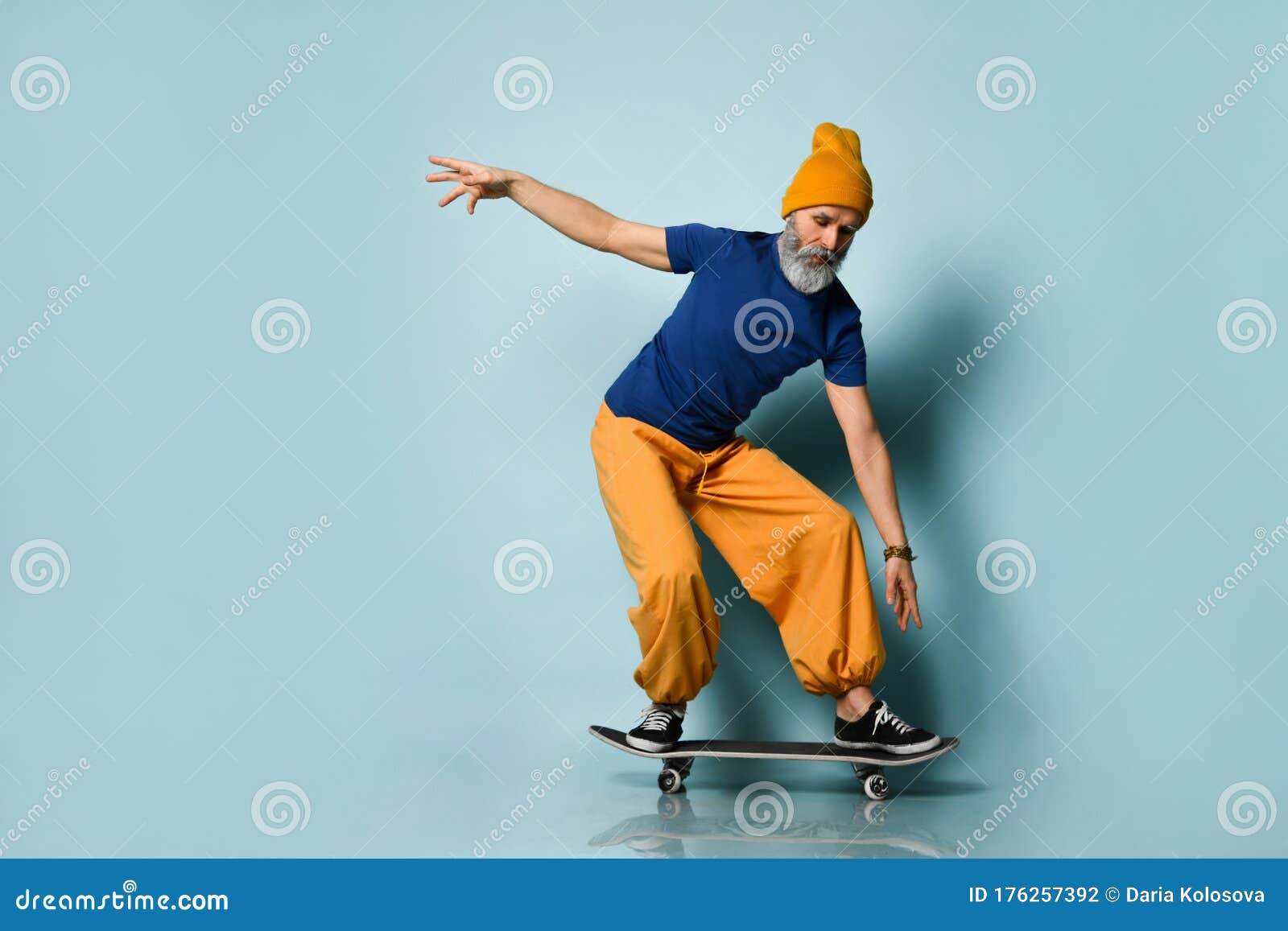 Bearded Aged Male in T-shirt, Orange Pants, Hat, Gumshoes. Riding Black ...