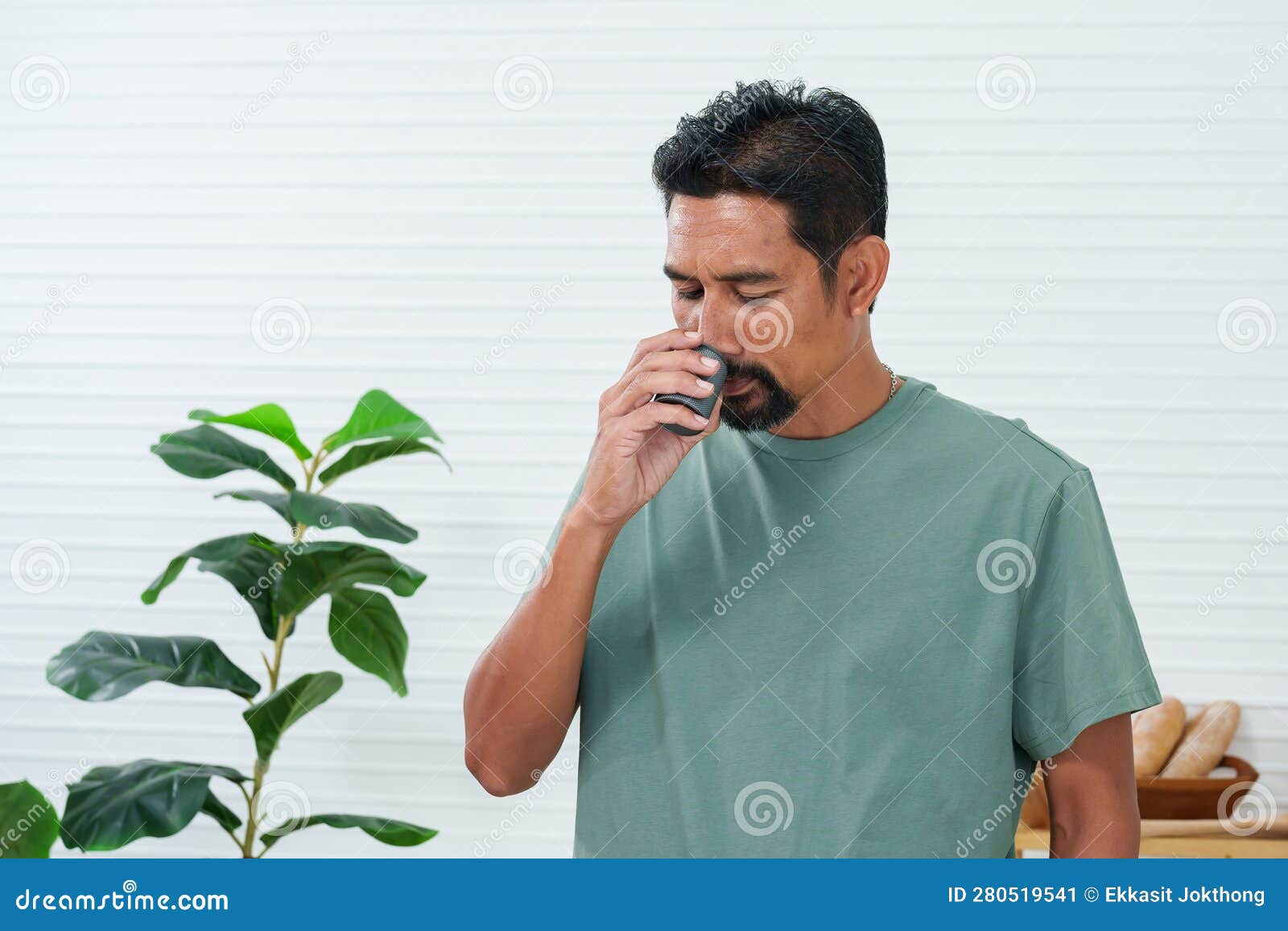 bearded asian man standing black smelling of meg coffee finished roasting to prepare to grind with a grinder, assemble the grinder