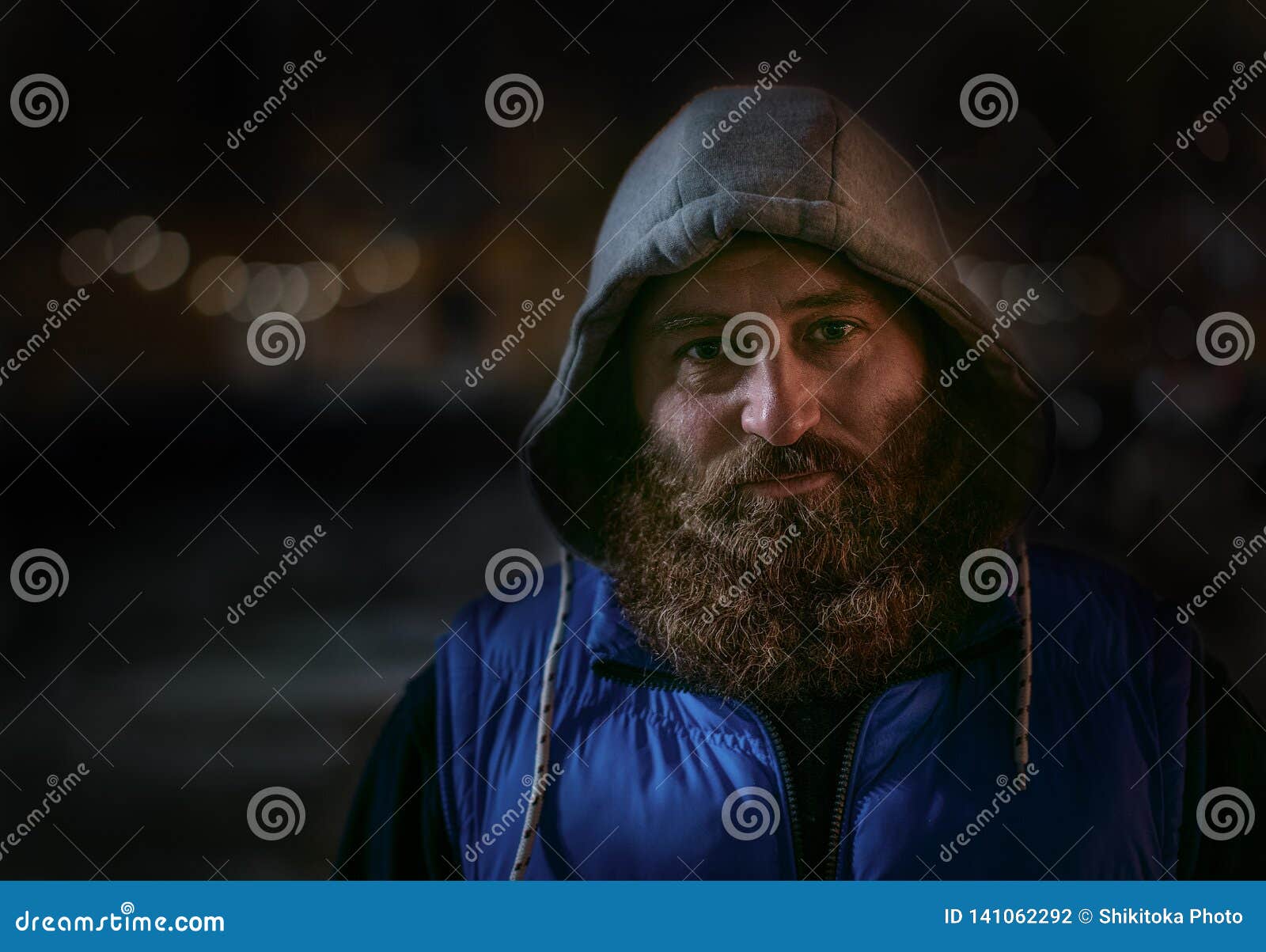 bearded caucasian man in blue sportswear looks at camera. big beard