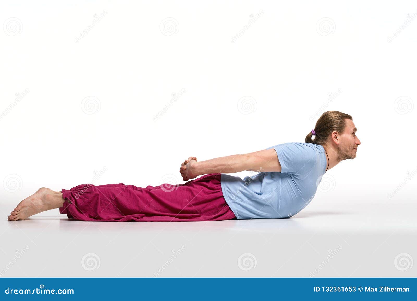 bearded longhair man practicing yoga. niralamba bhudjangasana pose.  on white