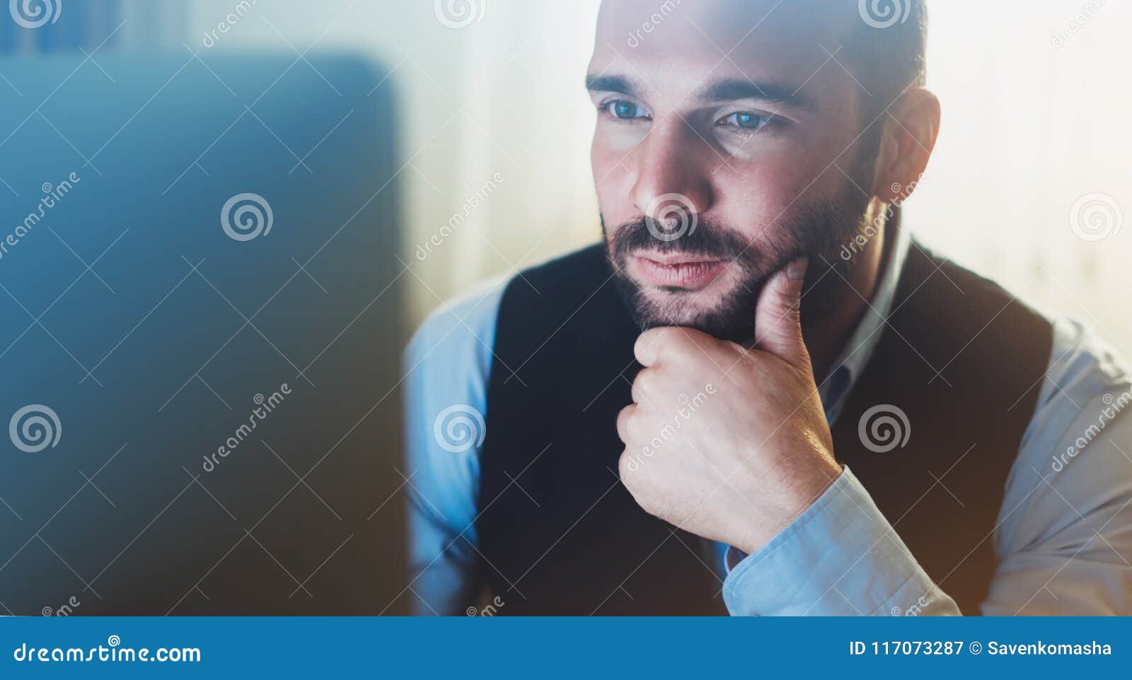bearded young businessman working on modern office. consultant man thinking looking in monitor computer. manager typing on keyboar