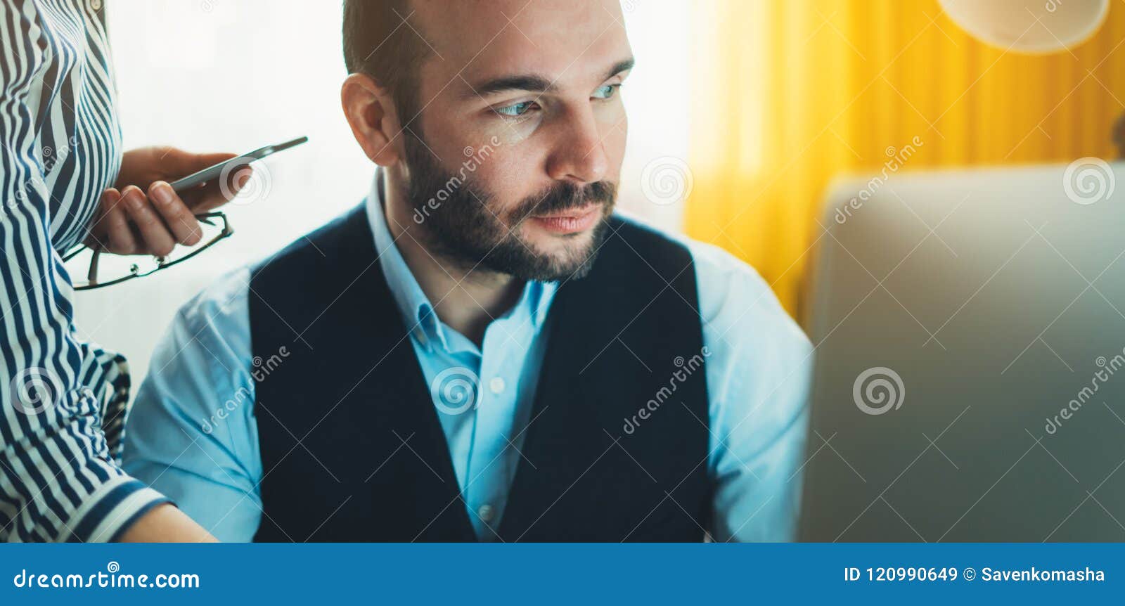 bearded young businessman working on modern office at night. consultant man thinking looking in monitor computer. manager typing o