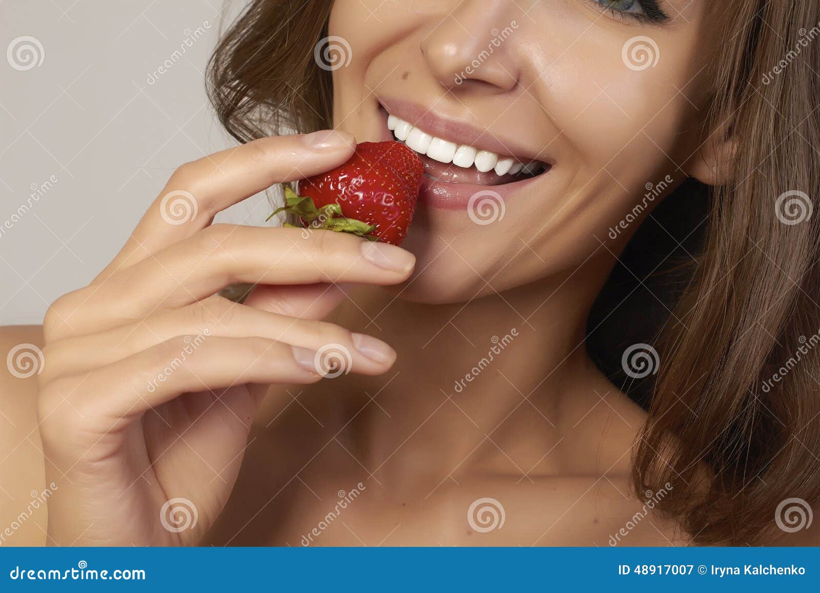 beatiful girl with perfect smile eat red strawberry white teeth and healthy food