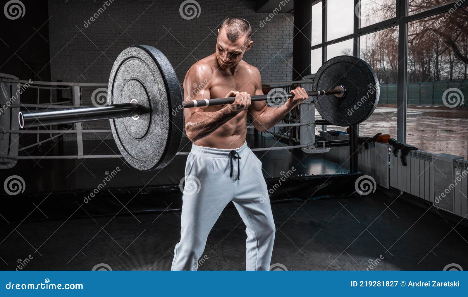 homme sportif s'entraînant avec haltère dans la salle de gym