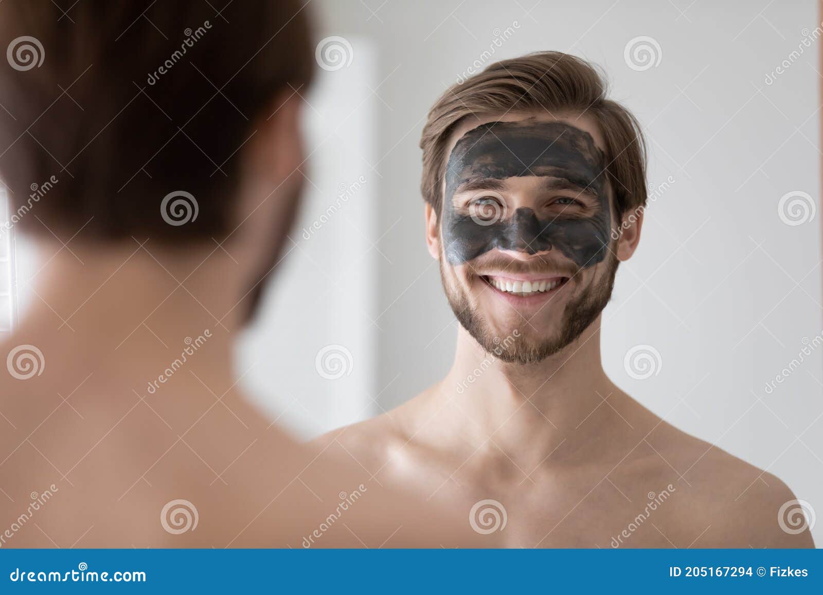 Beau Jeune Homme Souriant Avec Black Mask Regardant à Travers Le Miroir.  Photo stock - Image du acné, visage: 205167294