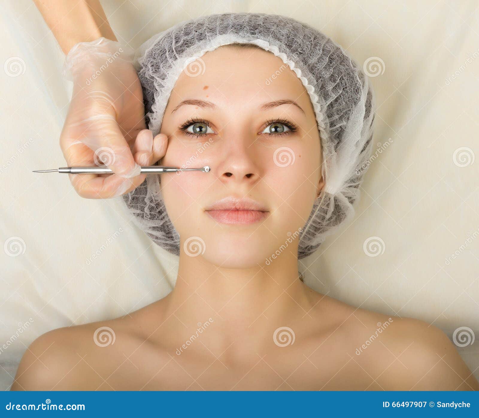 beautician examining the face of a young female client at spa salon. face cleaning, una cuchara. professional