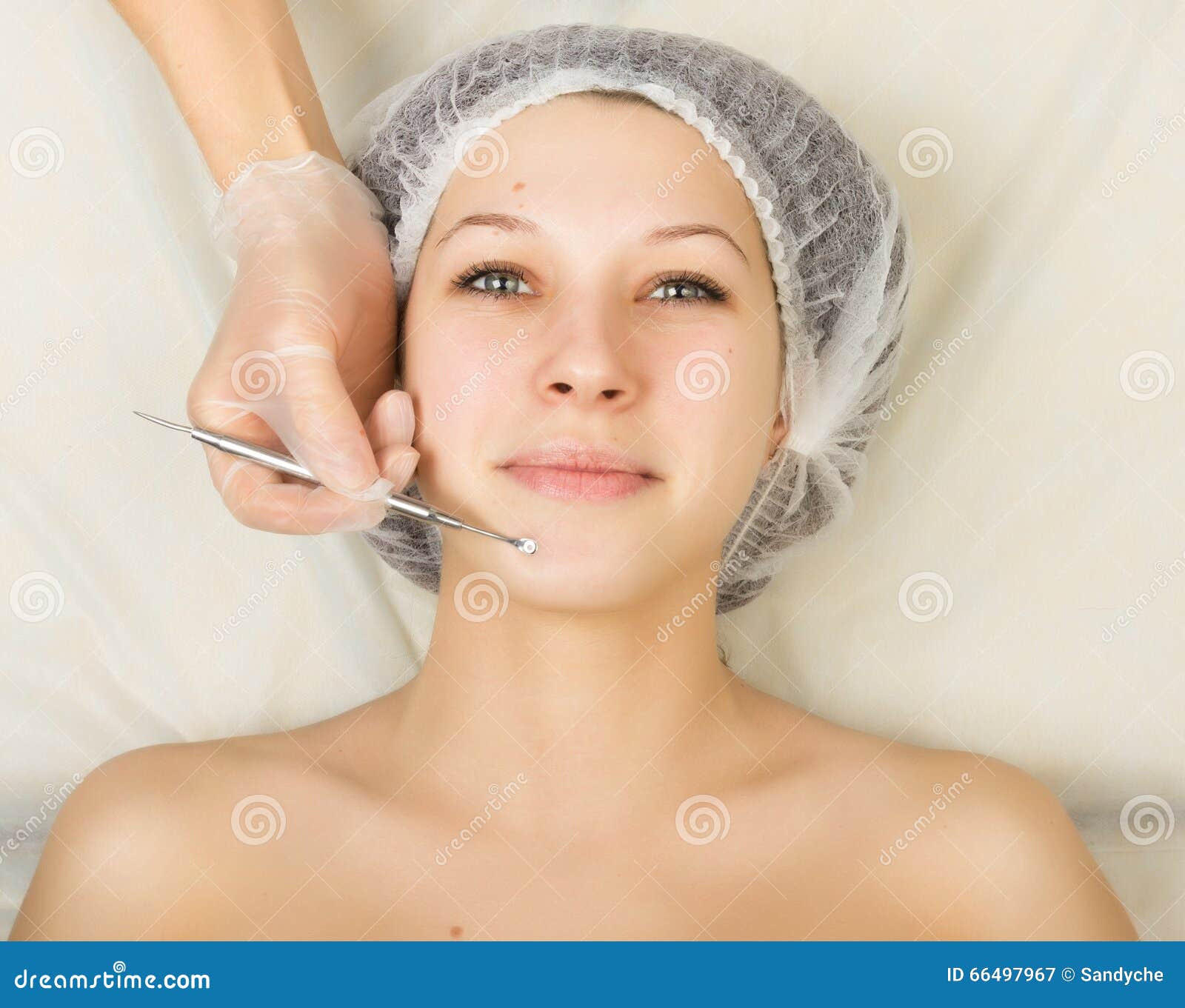beautician examining the face of a young female client at spa salon. face cleaning, una cuchara. professional