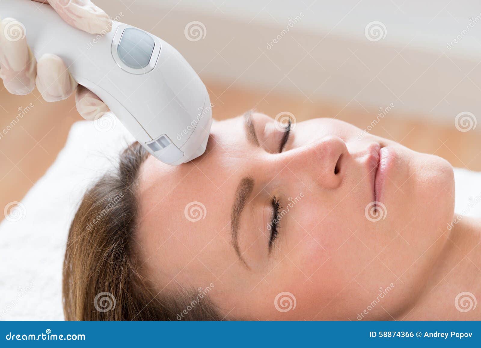 beautician giving laser epilation treatment to woman face
