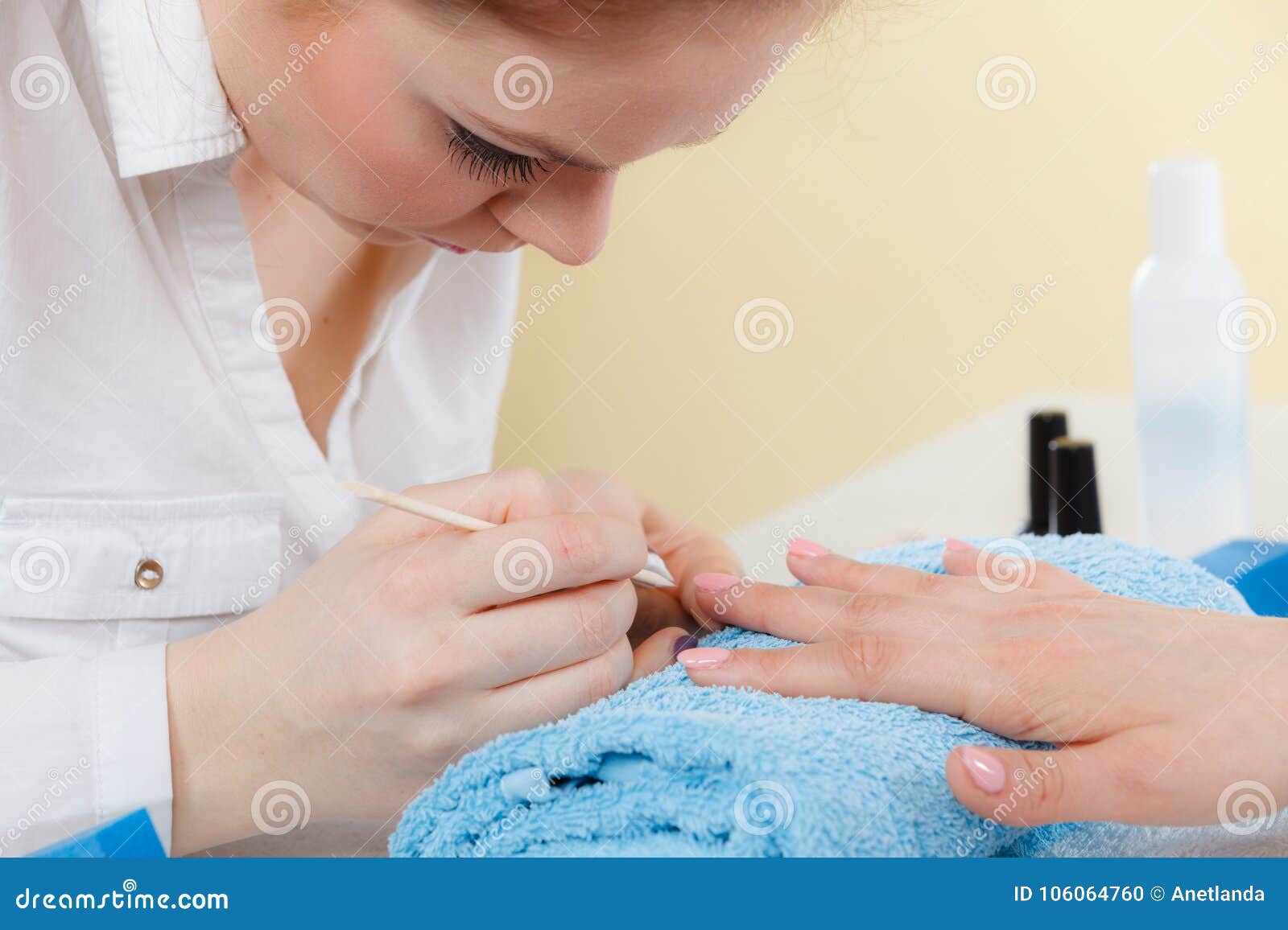 beautician preparing nails before manicure, pushing back cuticles