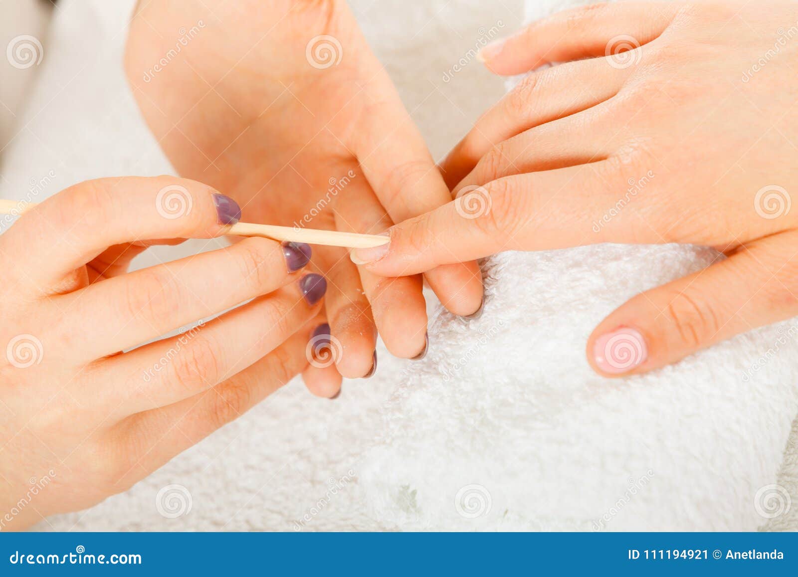 beautician preparing nails before manicure, pushing back cuticles