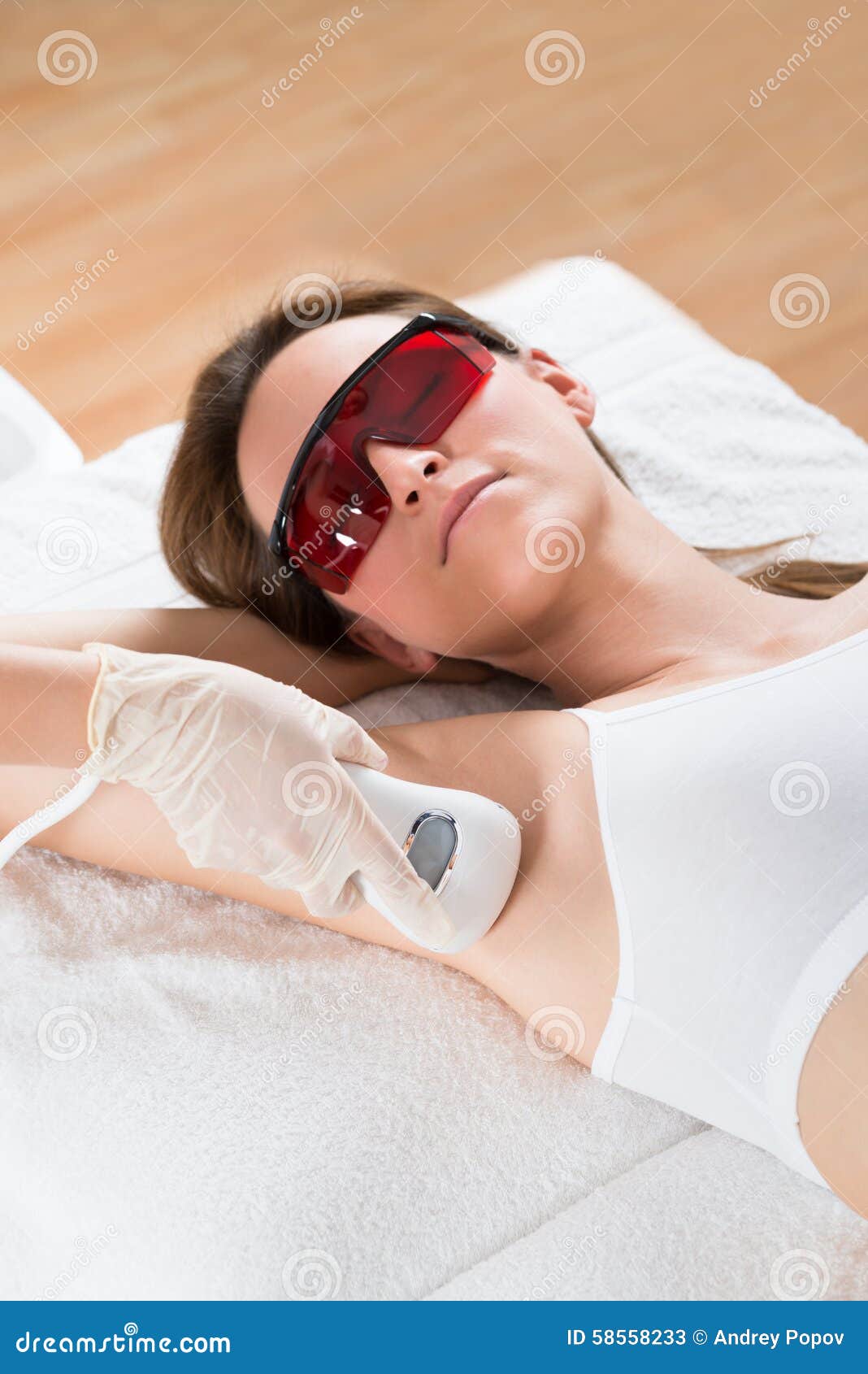 beautician removing hair of woman with epilator