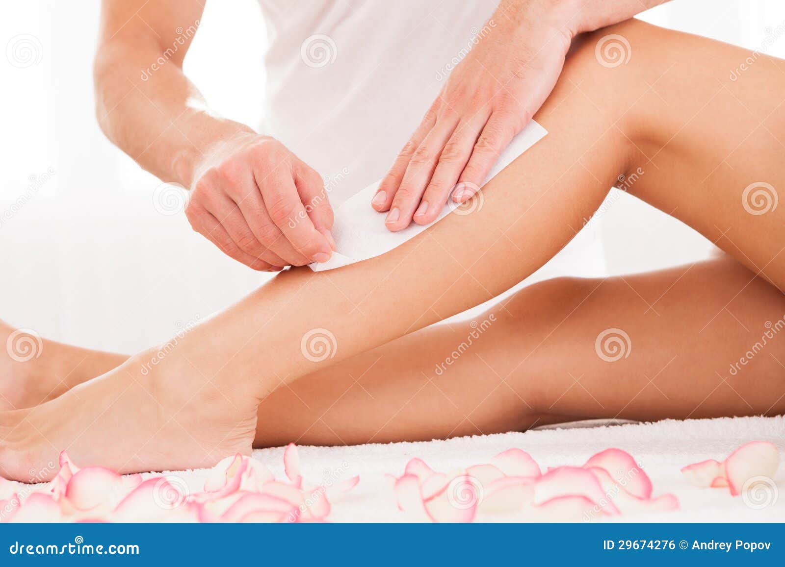 beautician waxing a woman leg