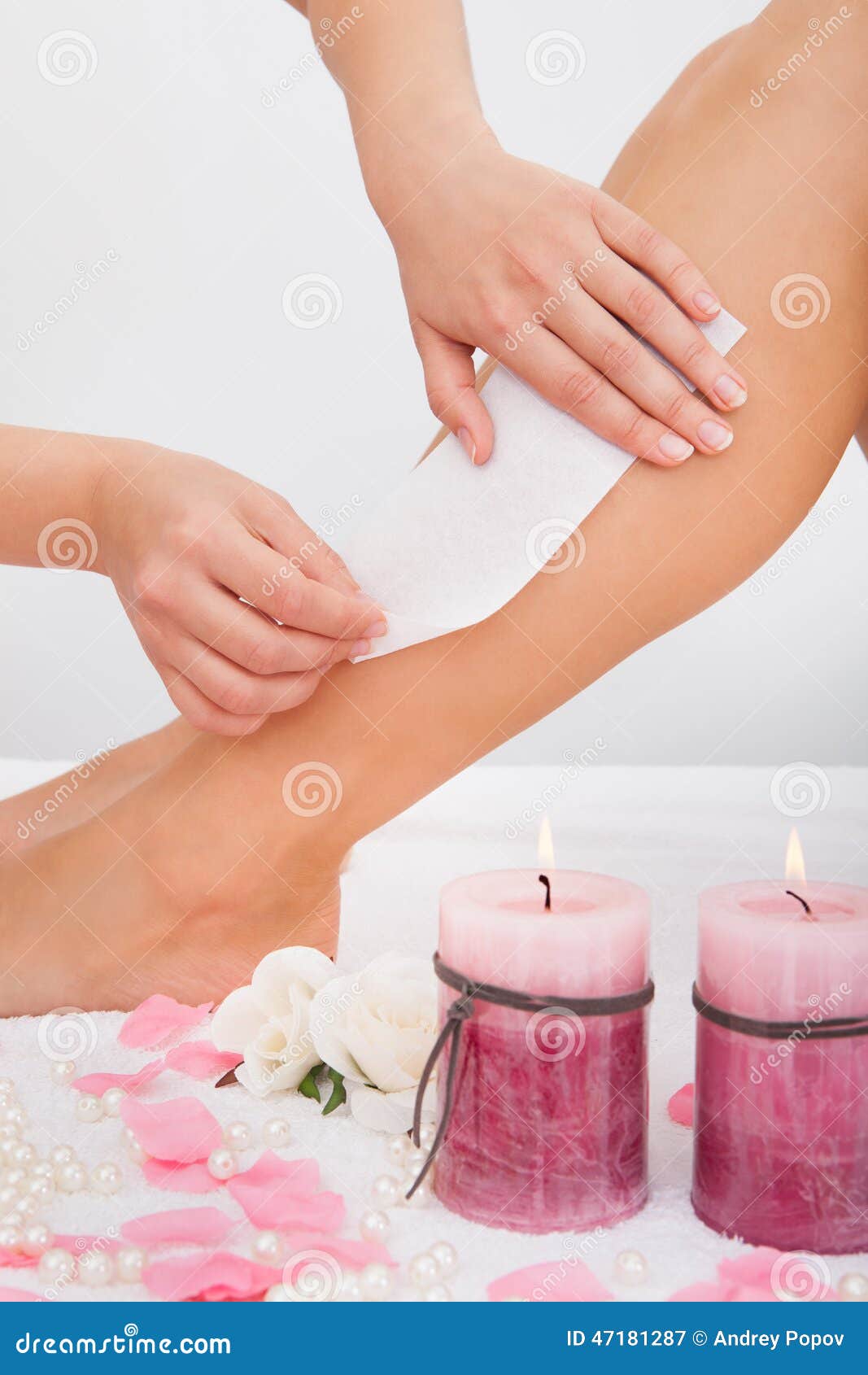 beautician waxing a woman's leg