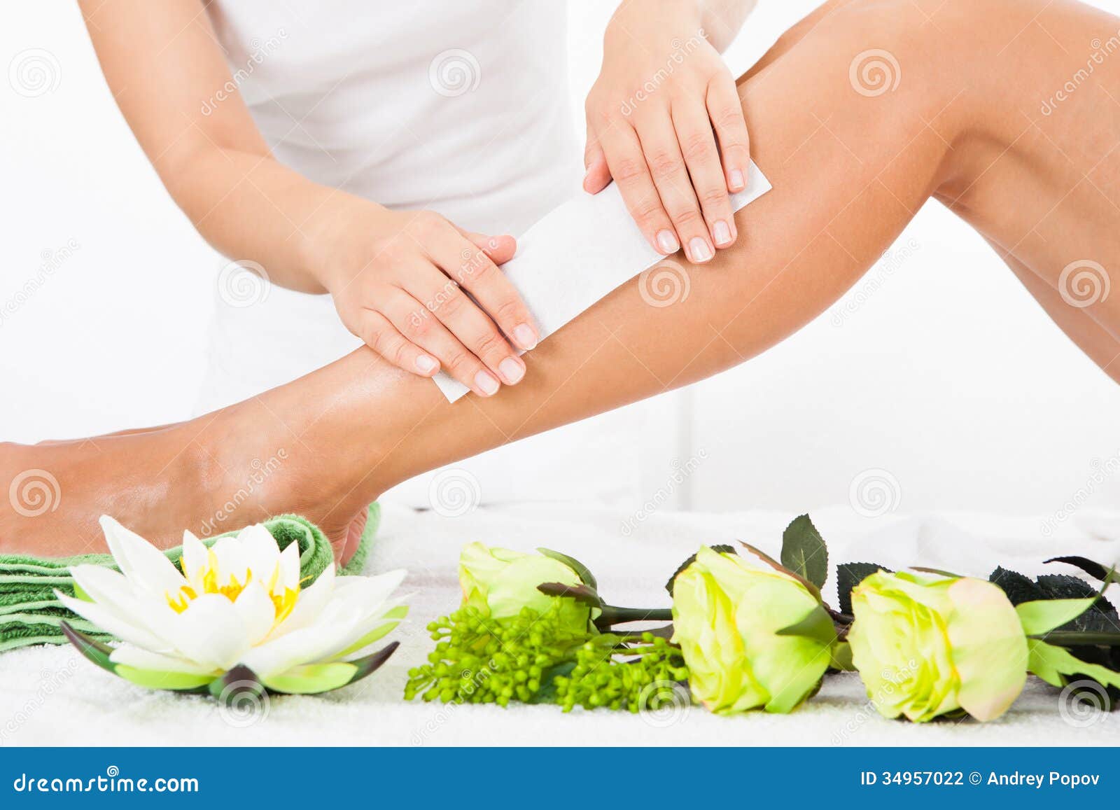 beautician waxing a woman's leg