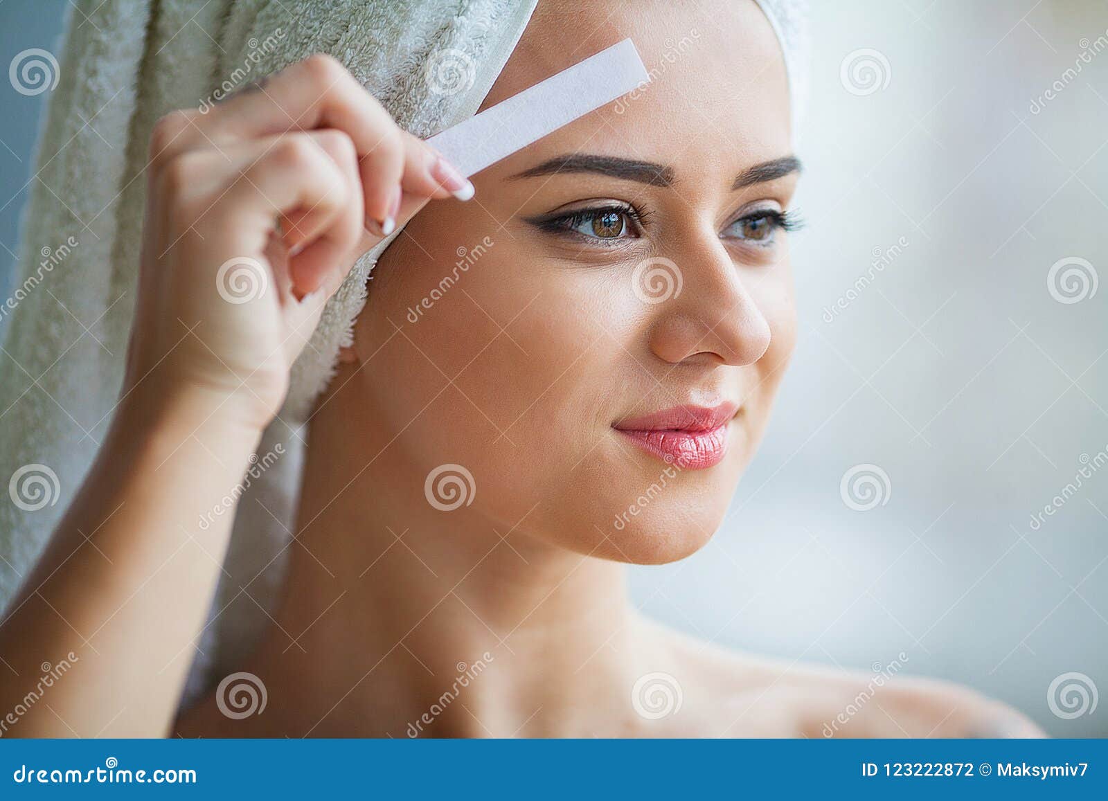 Beautician Waxing Young Woman`s Eyebrows in Spa Center Stock Photo