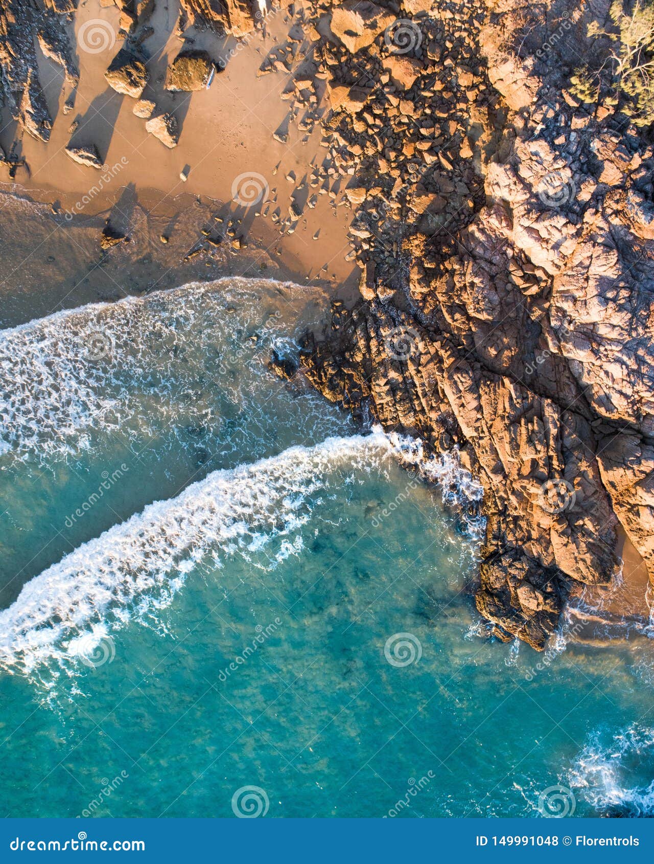 beautiful aerial view of a beach escape with nice beach, rocks and warm gentle waves
