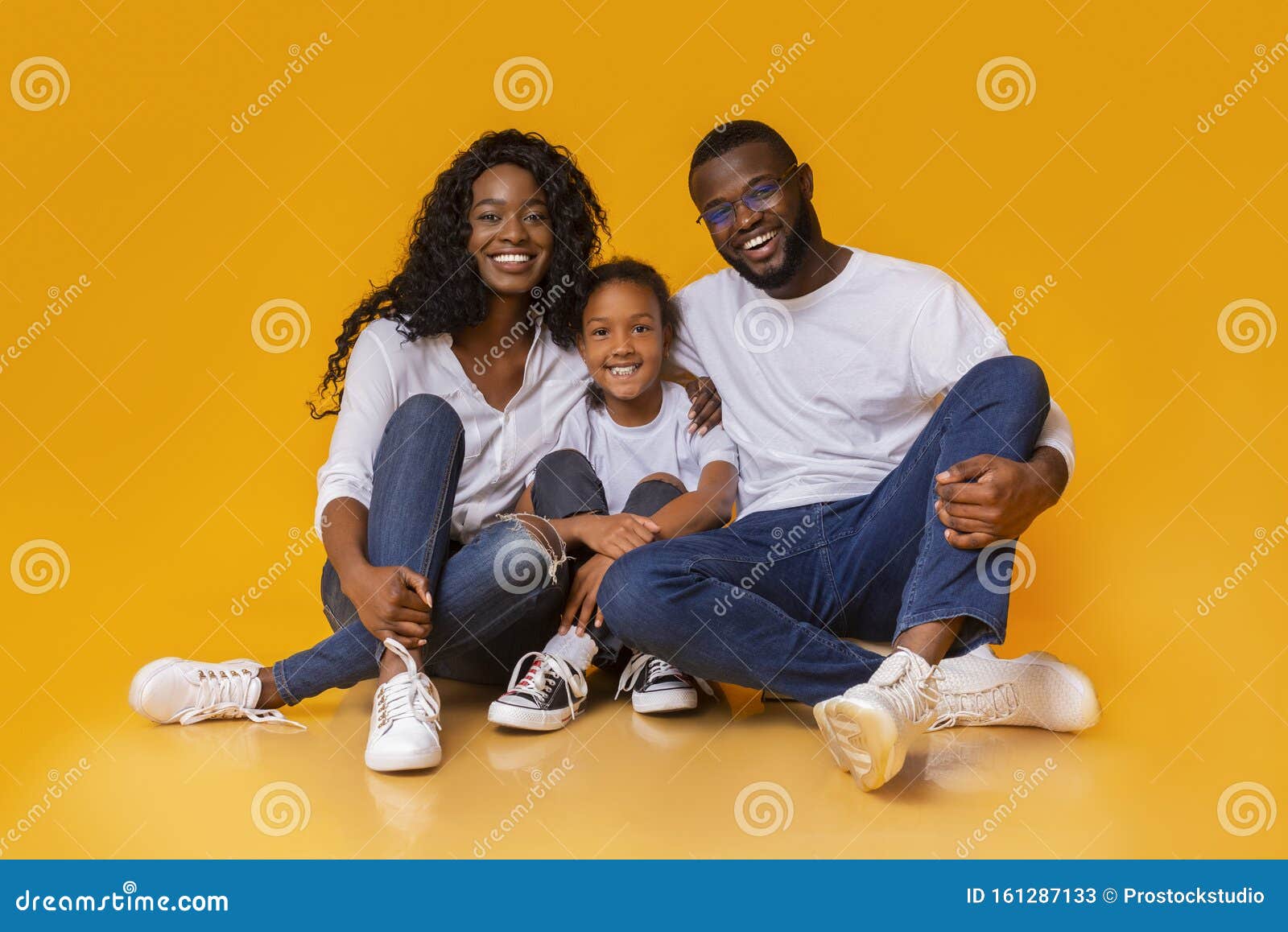 beautiful african american family sitting on floor and smiling