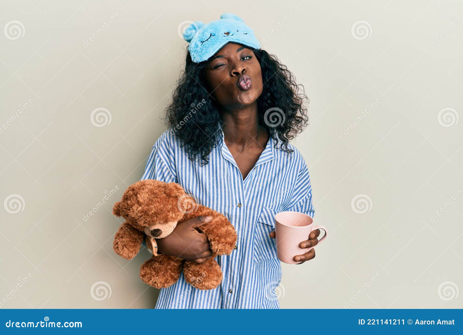 Beautiful African Young Woman Wearing Pajama, Holding Teddy Bear and  Drinking Coffee Looking at the Camera Blowing a Kiss Being Stock Image -  Image of emotion, wearing: 221141211