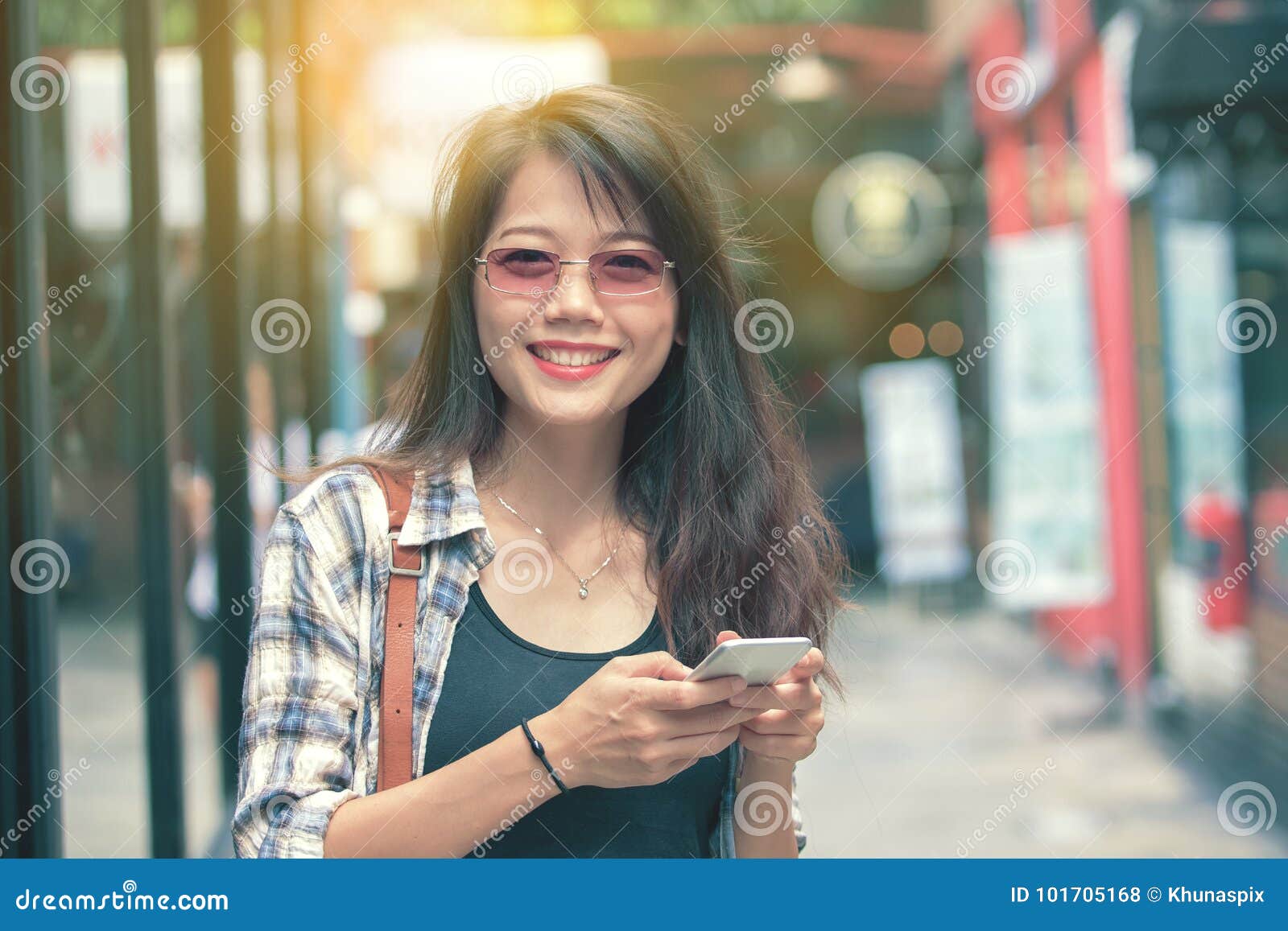 beautiful aisan woman toothy smiling face with smart phone in ha