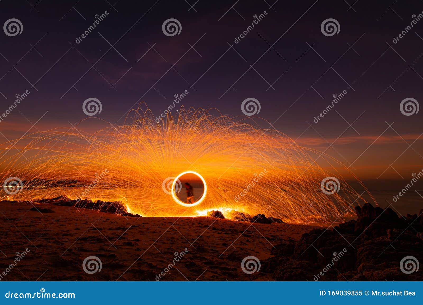 The Beautiful Art Fire Dancer Swing Fire Dancing Show on the Beach with Dark Clouds , Dark Sky