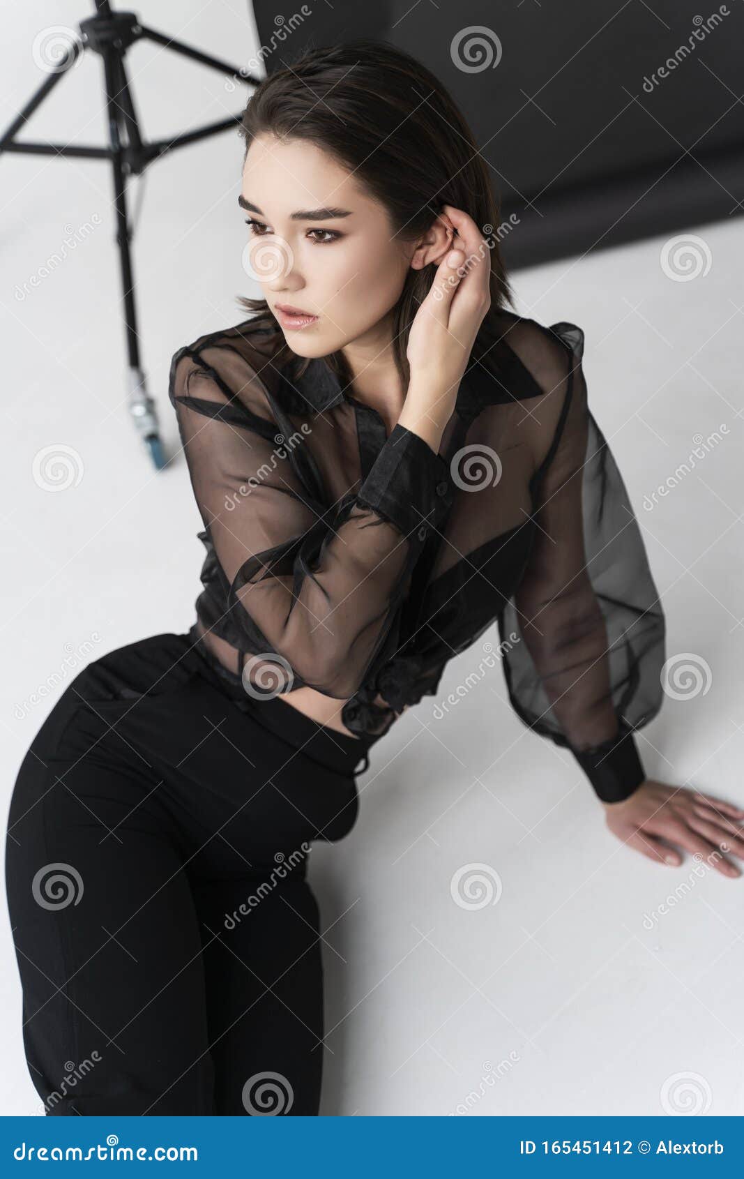 Beautiful Asian Girl Wearing Trousers, a Transparent Blouse and Bra Sits on  White Floor Near the Gray Studio Background. Stock Photo - Image of  earrings, happy: 165451412