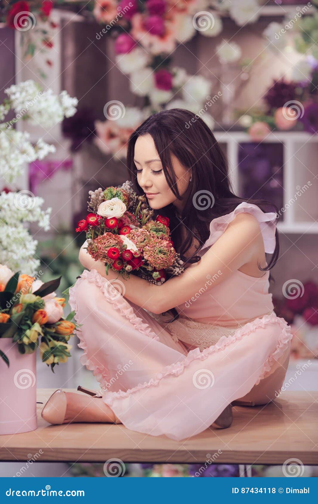 Beautiful Asian Woman Florist In Pink Dress With Bouquet Of Flowers In Hands In Flower Store