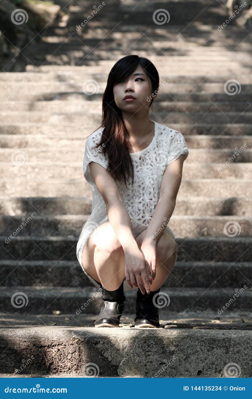 Beautiful Asian Woman Squatting On Cement Steps Stock Photo