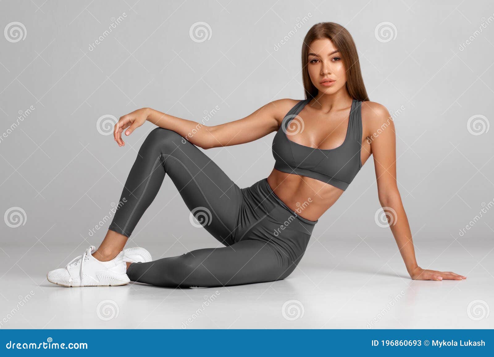 beautiful athletic girl, fitness woman on gray background