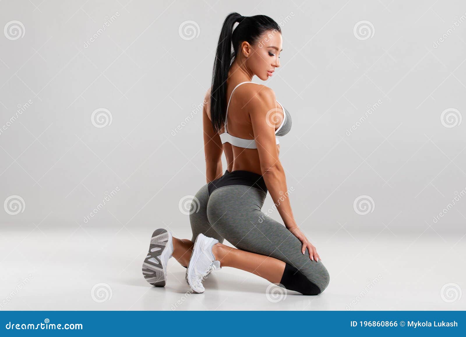 Fitness woman in leggings on gray background. Athletic girl with beautiful  butt Stock Photo