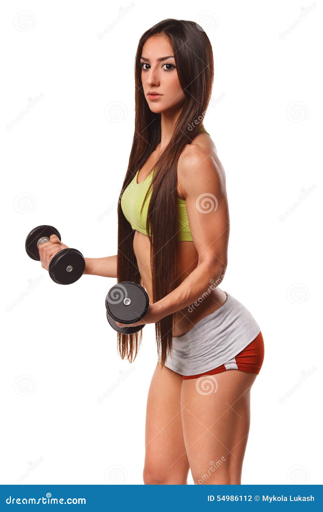 Beautiful athletic woman with long hair working out with dumbbells