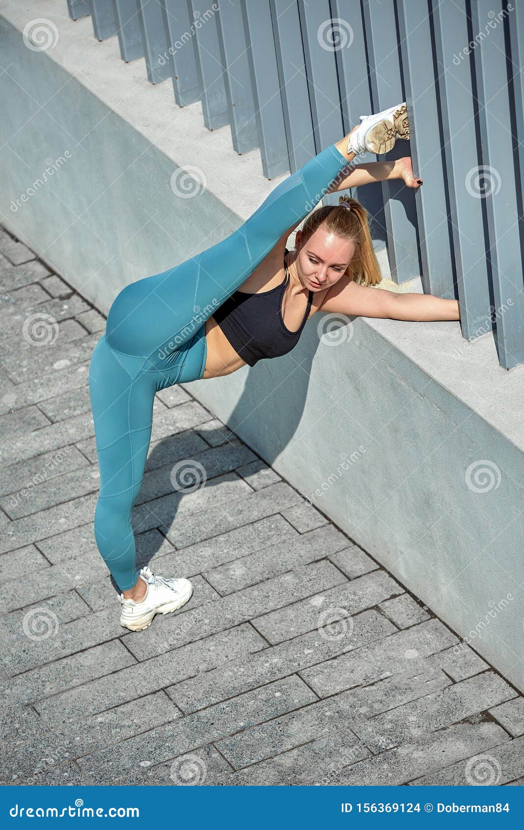 Beautiful Athletic Young Girl in Sportswear, Doing Exercises for Stretching  on the Street, the Element of Gymnastics Stock Photo - Image of caucasian,  dark: 156369124