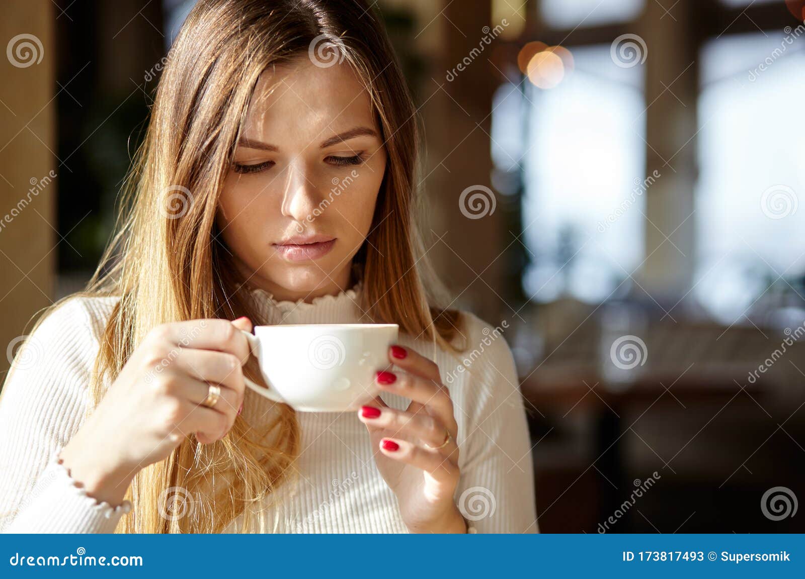 Beautiful Attractive Business Woman in a White Blouse Drinks Cofee in ...