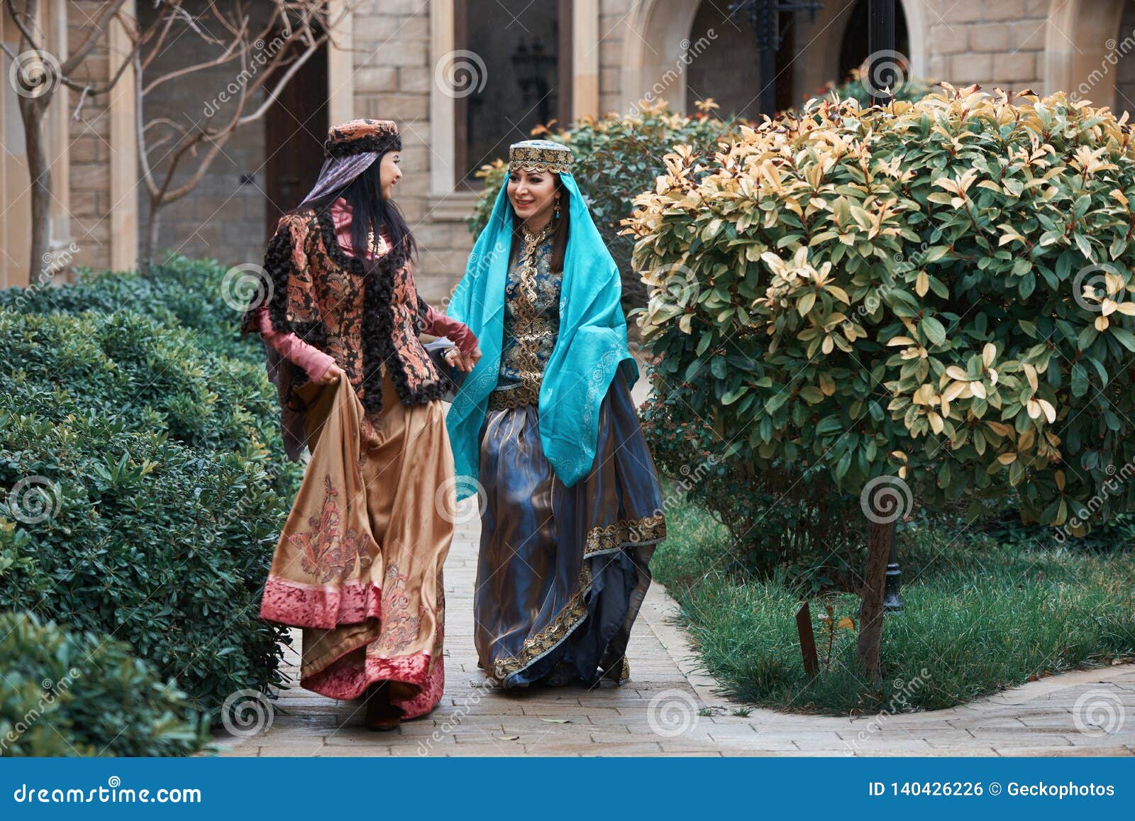 beautiful azeri women in traditional azerbaijani dress running by the wooden door