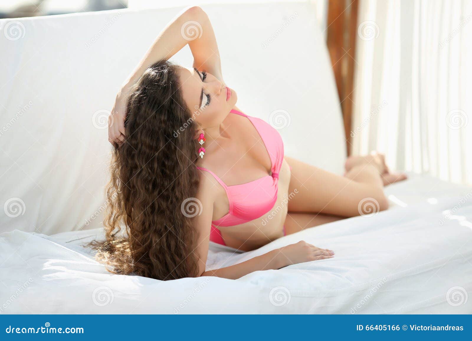 spanish girl laying on bed with a pink bikini