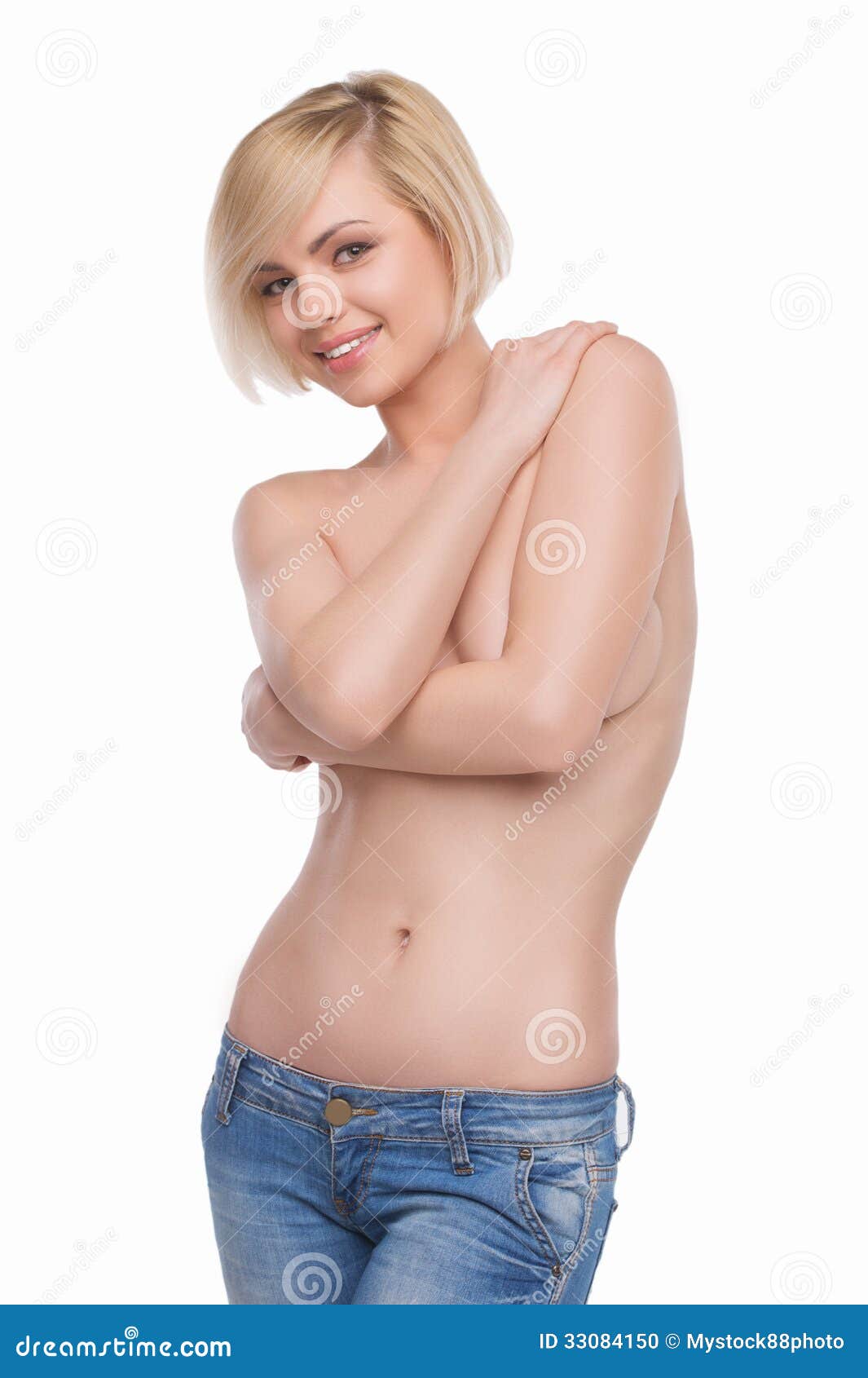 Beautiful blond in jeans. Beautiful shirtless woman covering breast with hands and smiling while isolated on white