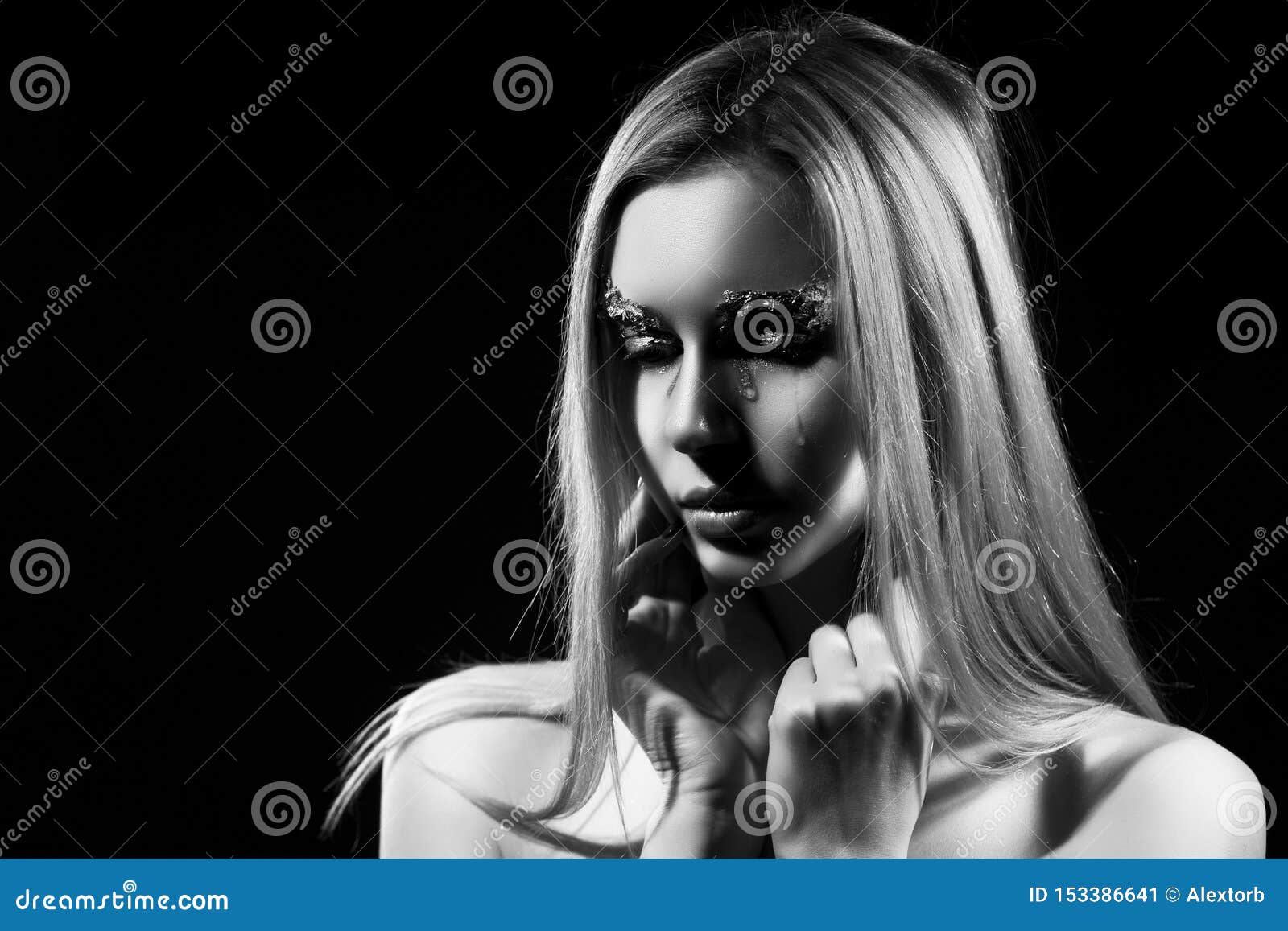 Foto de Beautiful topless blonde girl with hair falling on her face, stands  sideways covered with spider web, with a her hand covers her big boobs.  Black background. Artistic noir silhouette photo