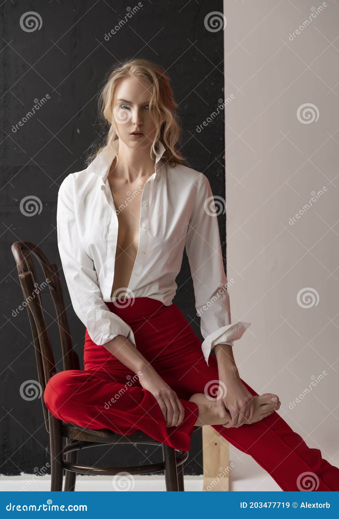 A Beautiful Blonde Curly Girl Wearing A Red Pants And A Blouse Unbuttoned On Her Braless Big