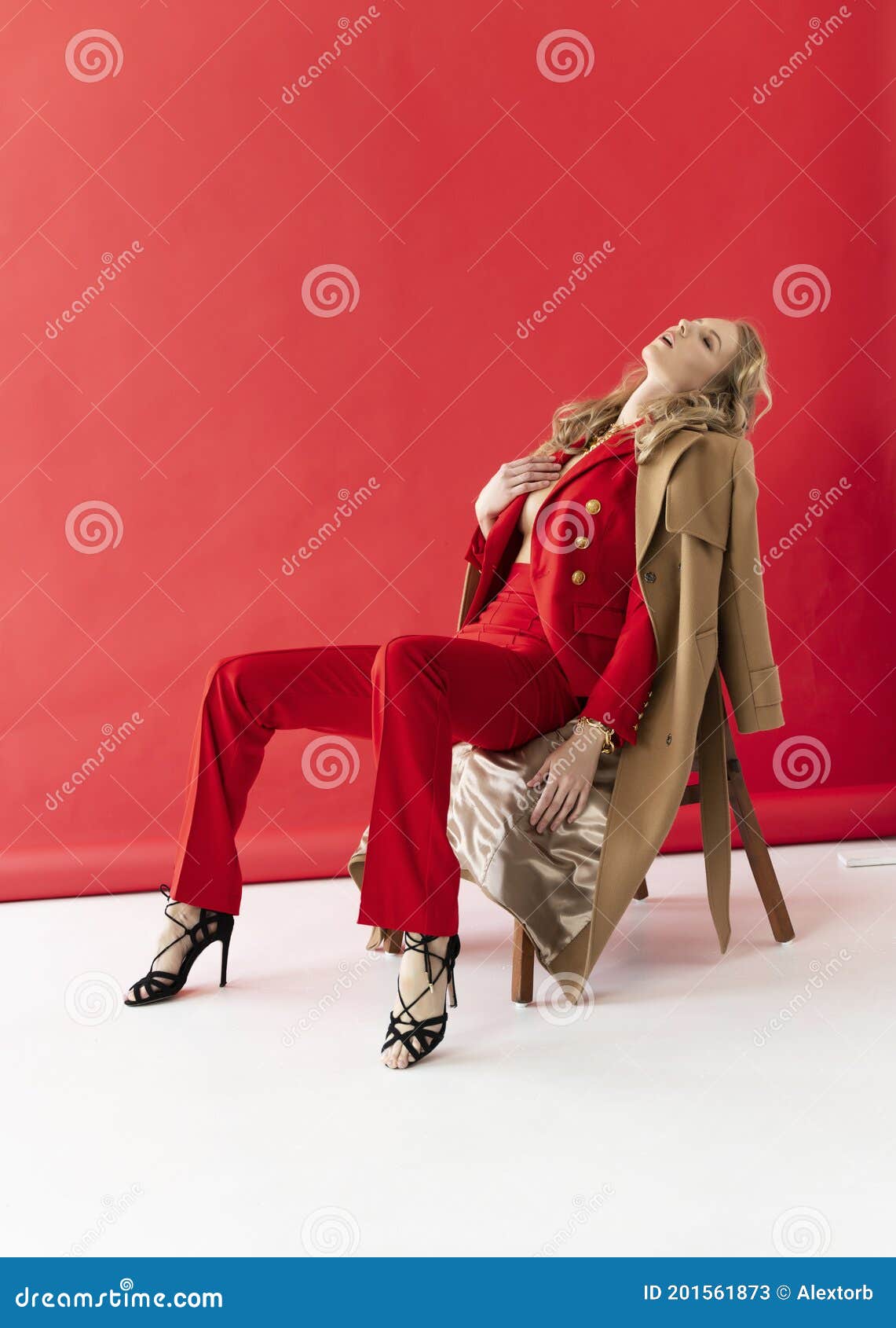 A Beautiful Blonde Curly Girl Wearing A Red Pantsuit Unbuttoned On Her Braless Big Breasts